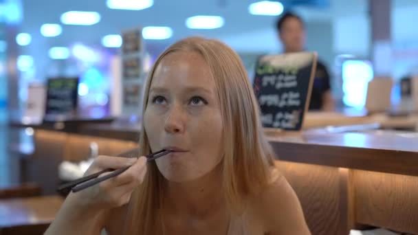 Uma jovem num restaurante japonês come sushi. Viagem ao Japão conceito — Vídeo de Stock