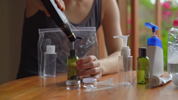 Wanita muda menempatkan kosmetik dan sampo dalam botol plastik cocok untuk membawa pesawat onboard. Peralatan perjalanan untuk pesawat. Konsep perjalanan — Stok Video