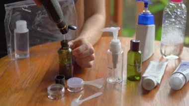 Genç kadın kozmetik ürünlerini ve şampuanını uçağa getirmek için uygun plastik şişelere koyar. Uçak için seyahat çantası. Seyahat kavramı