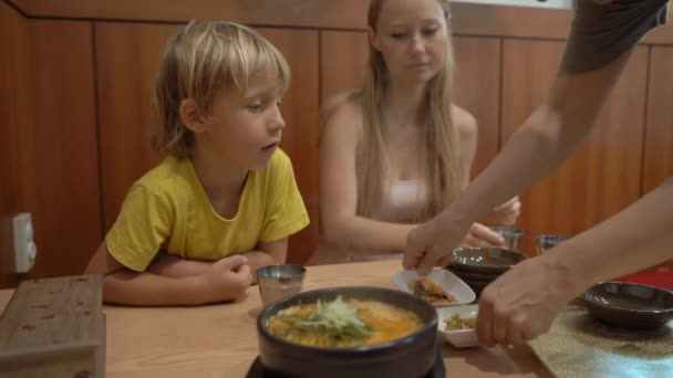 Familie genieten van traditionele Koreaanse gerechten noodle en kimpab in een restaurant — Stockvideo