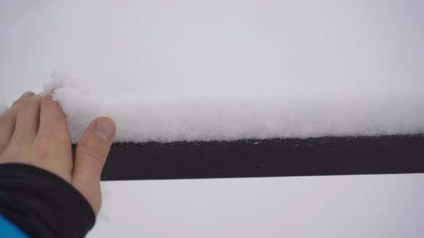 Ένας άντρας αγγίζει ένα χιόνι που έπεσε πρόσφατα. Σφηνάκι αργής κίνησης — Αρχείο Βίντεο