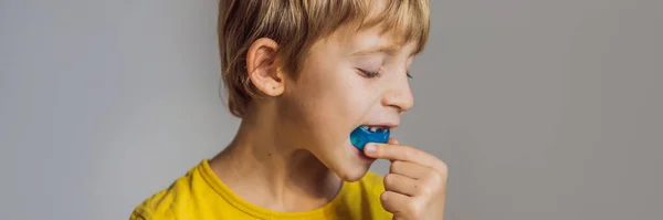 Il bambino di sei anni mostra un allenatore miofunzionale. Aiuta a pareggiare i denti in crescita e correggere il morso, sviluppare l'abitudine respiratoria della bocca. Corregge la posizione della lingua BANNER, FORMATO LUNGO — Foto Stock