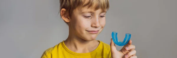 Šestiletý chlapec ukazuje myofunkční trenéra. Pomáhá vyrovnávat rostoucí zuby a správný skus, rozvíjet dýchací návyk v ústech. Oprava pozice jazyka Banner, Long Format — Stock fotografie