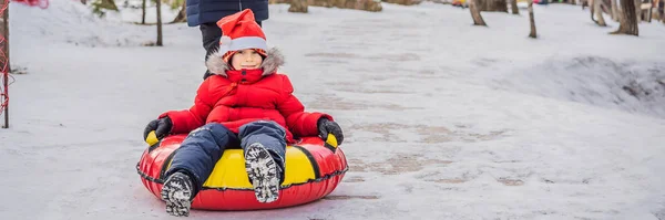 Mom son ride on an inflatable winter sled tubing. Winter fun for the whole family BANNER, LONG FORMAT — 스톡 사진