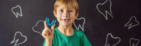 BANNER, LONG FORMAT Menino de seis anos mostra treinador miofuncional. Ajuda a equalizar os dentes em crescimento e mordida correta, desenvolver o hábito de respiração oral. Corrige a posição da língua — Fotografia de Stock