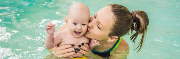 Schöne Mutter bringt süße Baby-Mädchen bei, wie man in einem Schwimmbad schwimmt. Kind hat Spaß im Wasser mit Mama-Banner, Langformat — Stockfoto
