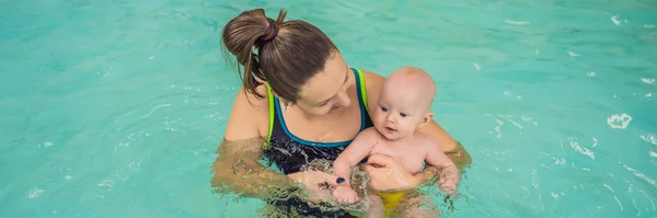 Bela mãe ensinando bebê bonito menina como nadar em uma piscina. Criança se divertindo na água com a mãe BANNER, LONG FORMAT — Fotografia de Stock