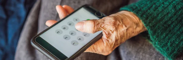 Пожилая женщина, сидящая на диване, пользуется мобильным телефоном — стоковое фото