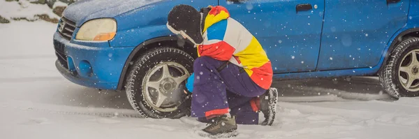 Téli baleset az úton. Egy ember kereket cserél hóesés közben. Téli problémák Banner, Hosszú formátum — Stock Fotó