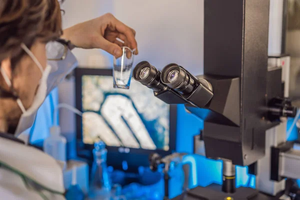 Valkoihoisen kemisti tieteellisen tutkijan muotokuva, joka käyttää mikroskooppia sisäkoronaviruksen laboratoriossa — kuvapankkivalokuva