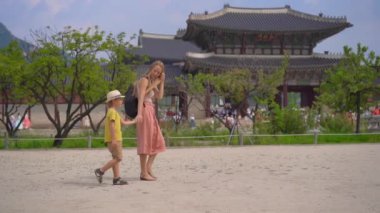 Genç kadın ve küçük oğlu Güney Kore, Seul 'deki antik sarayı ziyaret ediyorlar. Kore konseptine seyahat. Yavaş çekim.
