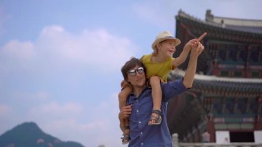 Genç adam ve küçük oğlu Güney Kore, Seul 'deki antik sarayı ziyaret ediyorlar. Kore konseptine seyahat. Yavaş çekim.