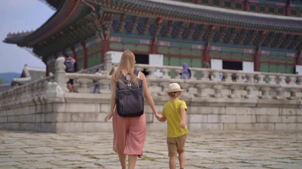 Молодая женщина и ее маленький сын посещают древний дворец в Сеуле, Южная Корея. Путешествие в Корею. Слоумоушн — стоковое видео