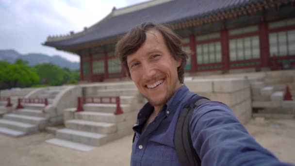Jovem turista visita um antigo palácio em Seul, Coreia do Sul. Viajar para a Coreia conceito. Tiro em câmara lenta — Vídeo de Stock