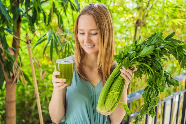 Young woman drinks Celery Juice, Healthy Drink, bunch of celery on a wooden background — Stock Photo, Image