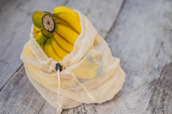 Banana in una borsa riutilizzabile su una superficie elegante cucina in legno. Concetto di zero rifiuti, concetto di plastica libera. Alimentazione sana e pulita dieta e disintossicazione. Frutta estiva — Foto Stock