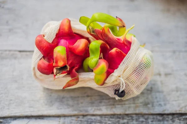 Dragon fruit σε μια επαναχρησιμοποιήσιμη τσάντα σε μια κομψή ξύλινη επιφάνεια κουζίνας. Σκέψη μηδενικών αποβλήτων, πλαστική ελεύθερη έννοια. Υγιεινή διατροφή και αποτοξίνωση. Κριθάρι — Φωτογραφία Αρχείου