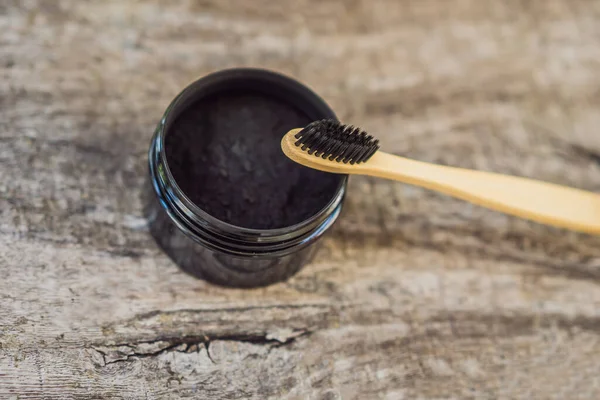 Activated charcoal powder for brushing and whitening teeth. Bamboo eco brush