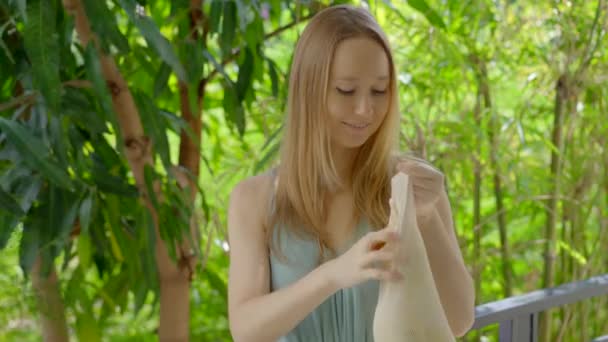 若い女性は再利用可能な袋にいくつかのマンゴーの果物を置く。プラスチックで汚染を減らすというコンセプト。削減と再利用 — ストック動画