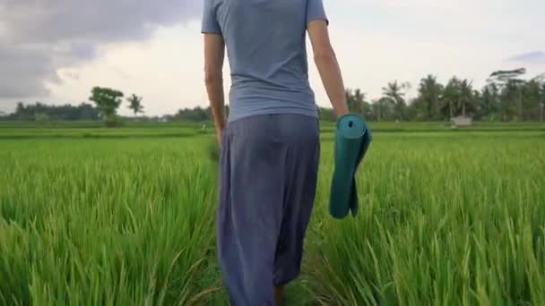 Ein junger Mann macht ein Yoga-Training auf einem schönen Reisfeld. Konzept Reise nach Asien — Stockvideo