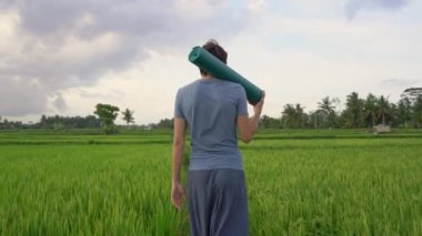 Genç bir adamın güzel bir pirinç tarlasında yoga eğitimi var. Asya 'ya Seyahat