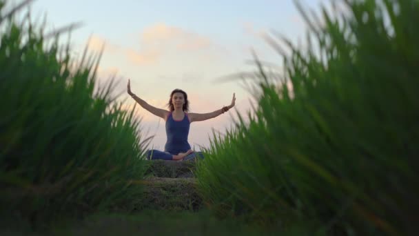 Una giovane donna ha una formazione di yoga su una bella risaia. Viaggio in Asia concetto — Video Stock