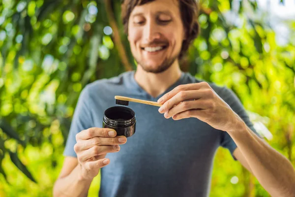 Young man brush teeth using Activated charcoal powder for brushing and whitening teeth. Bamboo eco brush — Stock Photo, Image