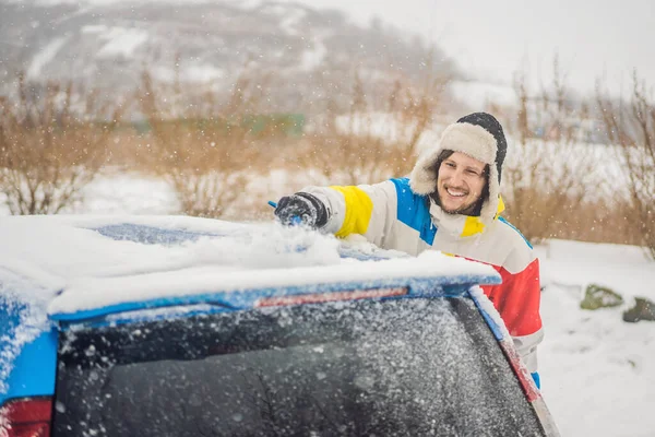 Quitar la nieve del coche con un cepillo — Foto de Stock