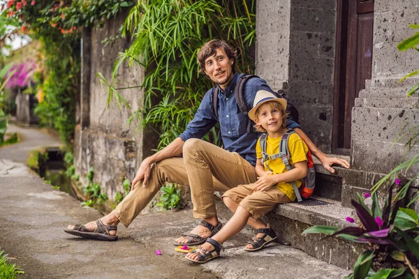 Otec a syn turisté na Bali procházky úzkými útulnými uličkami Ubud. Bali je oblíbenou turistickou destinací. Cestování na Bali. Koncept cestování s dětmi — Stock fotografie