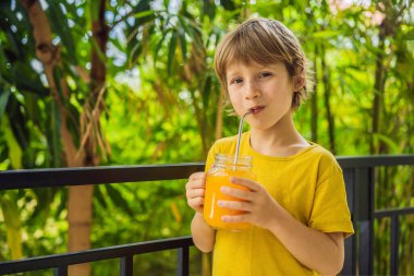 Kahvaltıda portakal suyu içen tatlı çocuk.