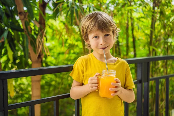 Lindo chico bebiendo jugo de naranja para el desayuno — Foto de Stock