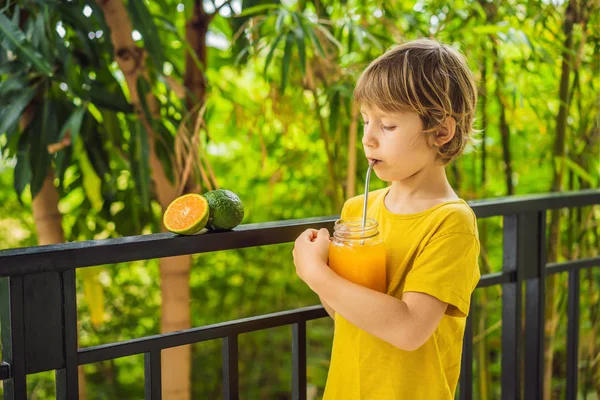 Lindo chico bebiendo jugo de naranja para el desayuno — Foto de Stock