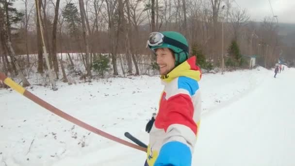 Ein Mann fährt mit einem Seillift den Skihang hinauf. Winterfreizeitkonzept. Zeitlupenschuss — Stockvideo