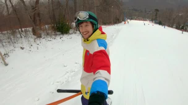 ロープのリフターに乗ってスキー場を駆け上がる男。冬のレクリエーションコンセプト — ストック動画