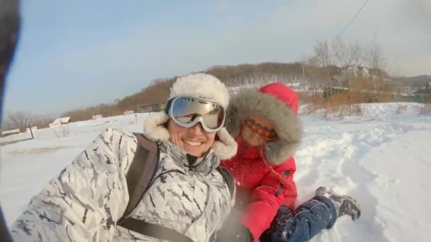 Een jongeman en zijn zoontje hebben plezier in de sneeuw na een grote sneeuwval. Winterconcept. Langzame schot — Stockvideo