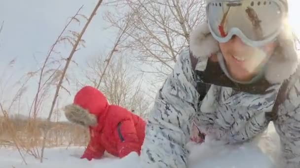 한 젊은이와 그 의아들은 큰 눈이 내린 후에 눈 주위에서 재미있게 놀고 있다. 겨울 개념. 느린 모션 샷 — 비디오