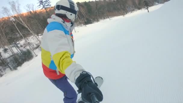 Un hombre monta en una tabla de snowboard por la pista de esquí. Concepto de recreación invernal. Disparo en cámara lenta — Vídeos de Stock