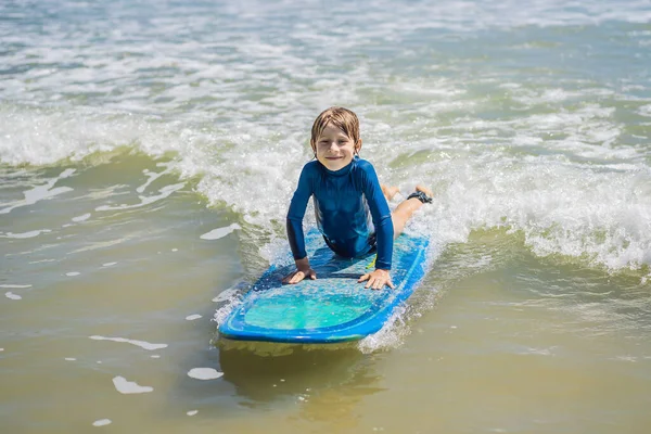 Niño sano aprendiendo a surfear en el mar o en el océano — Foto de Stock