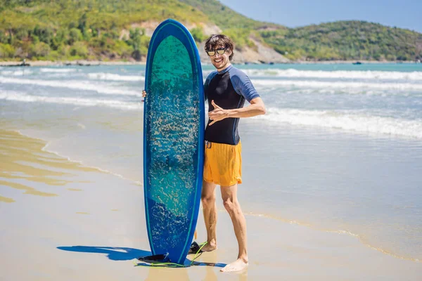 Surfer houden een surfplank op strand — Stockfoto