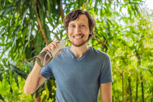 Giovane uomo utilizza un irrigatore orale per lavarsi i denti — Foto Stock