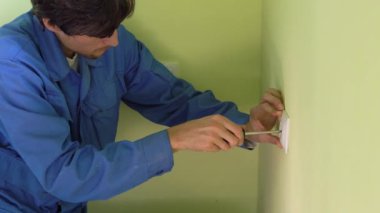 Soket yüklemeyi yapan genç profesyonel elektrikçi closeup çekim.