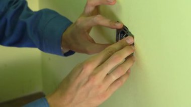 Soket yüklemeyi yapan genç profesyonel elektrikçi closeup çekim.