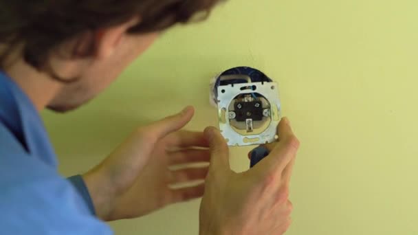 Closeup shot of young professional electrician doing socket installation. — Stock Video