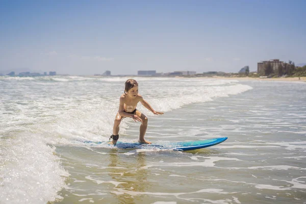 Zdravý mladý kluk učí surfovat v moři či oceánu — Stock fotografie