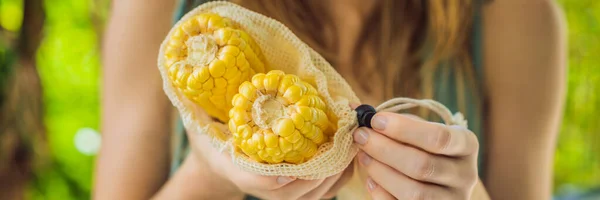 Jagung dalam tas yang bisa digunakan kembali di tangan seorang wanita muda. Nol konsep limbah BANNER, LONG FORMAT — Stok Foto