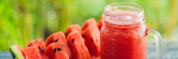 Glas watermeloen smoothie en een stuk watermeloen op een houten tafel Banner, Long Format — Stockfoto
