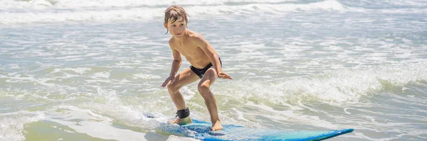 Healthy young boy learning to surf in the sea or ocean BANNER, LONG FORMAT — Stock Photo, Image