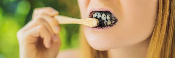 Giovane donna lavarsi i denti utilizzando carbone attivo in polvere per spazzolare e sbiancare i denti. Spazzola ecologica di bambù BANNER, FORMATO LUNGO — Foto Stock