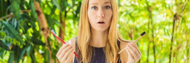 Banner, Long Format Woman 'ın elinde doğal bambu diş fırçası ve plastik diş fırçası var. Kırsal arka plan. Sürdürülebilir yaşam tarzı kavramı. Sıfır. Plastiksiz ögeler