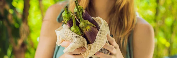 Yeniden kullanılabilir bir çantadaki patlıcan genç bir kadının elinde. Sıfır atık konsepti Banner, Uzun Biçim — Stok fotoğraf